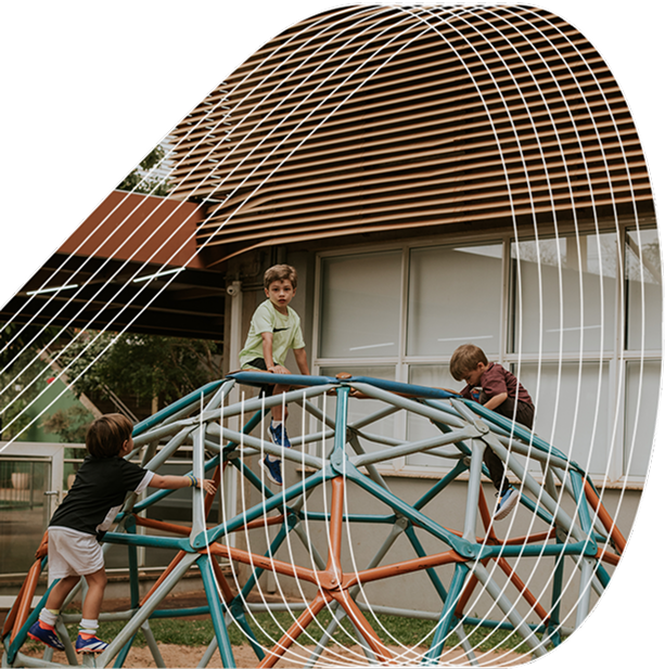 Three children climb on a geometric playground dome structure outside a building, with abstract white lines overlaid on the image.